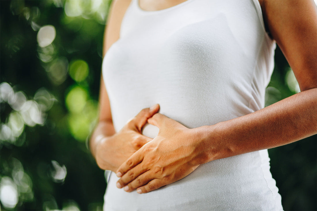 Woman holding stomach from bloating discomfort and gut issues
