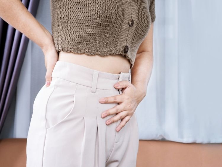 Woman holding her stomach from period bloating