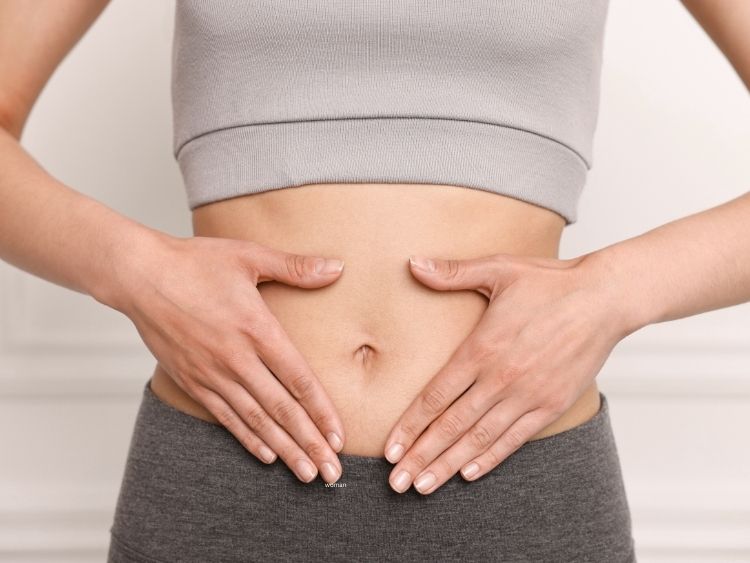 Woman holding hands over her stomach for good digestion
